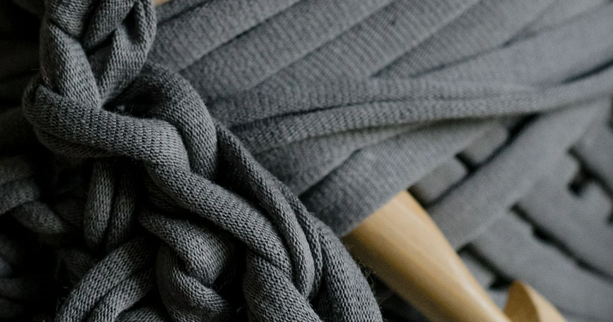 Close-up of dark gray crochet fabric with a textured stitch pattern.
